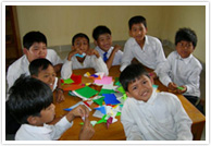 折り紙を楽しむ好奇心旺盛な子供たち。素朴で澄んだ眼が印象的です。